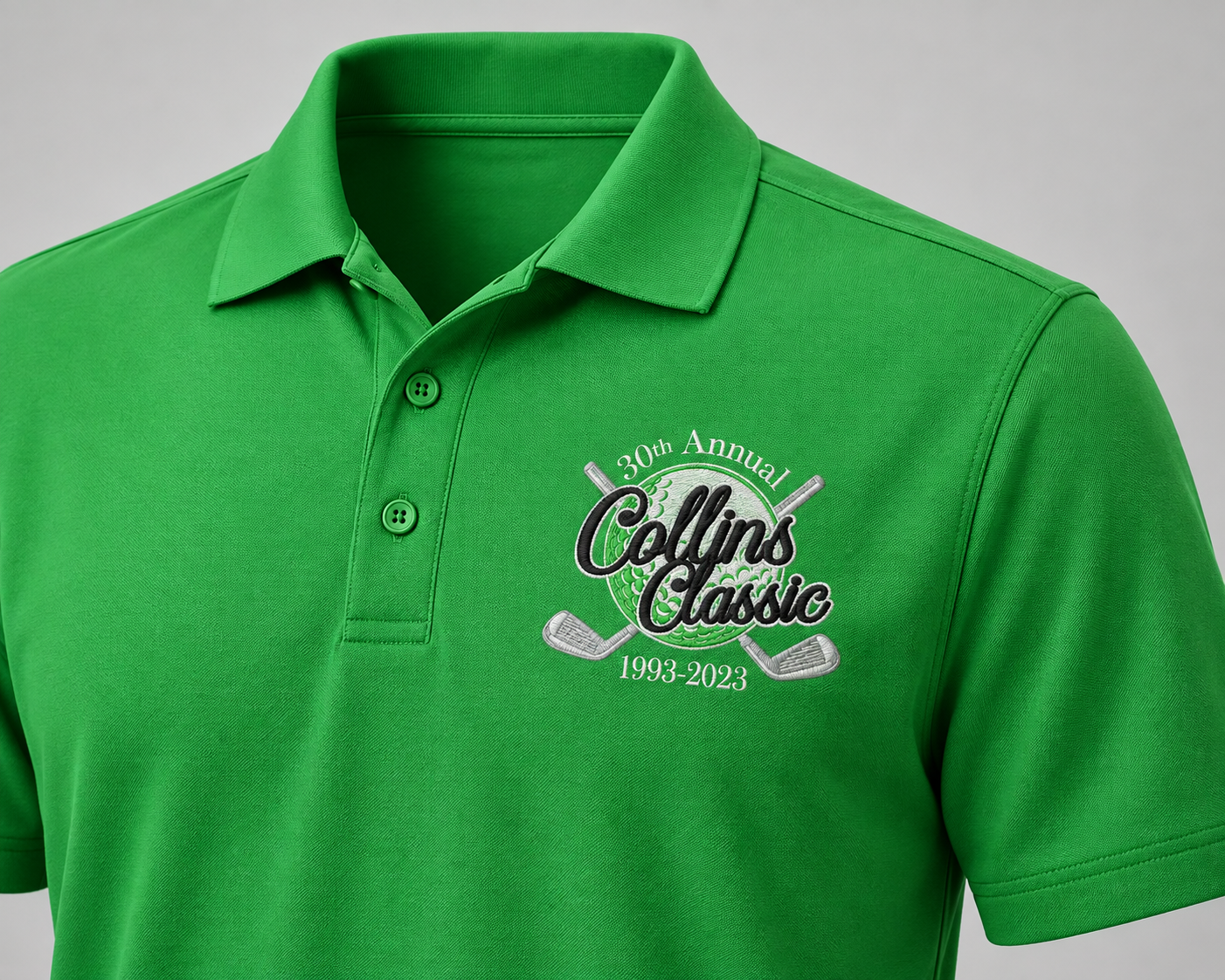 Three-color Collins Classic anniversary logo embroidered on the left chest of a Kelly green polo